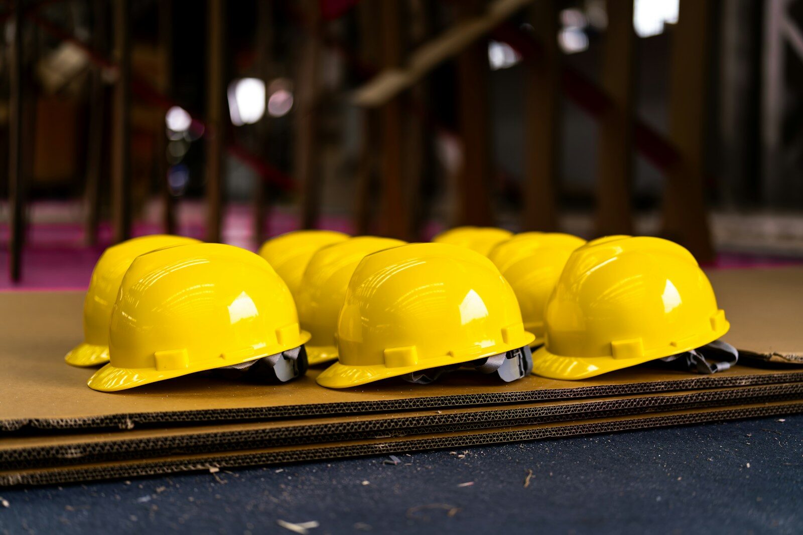 Several bright yellow hard hats are neatly lined up