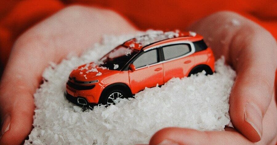 person holding red vehicle die-cast model